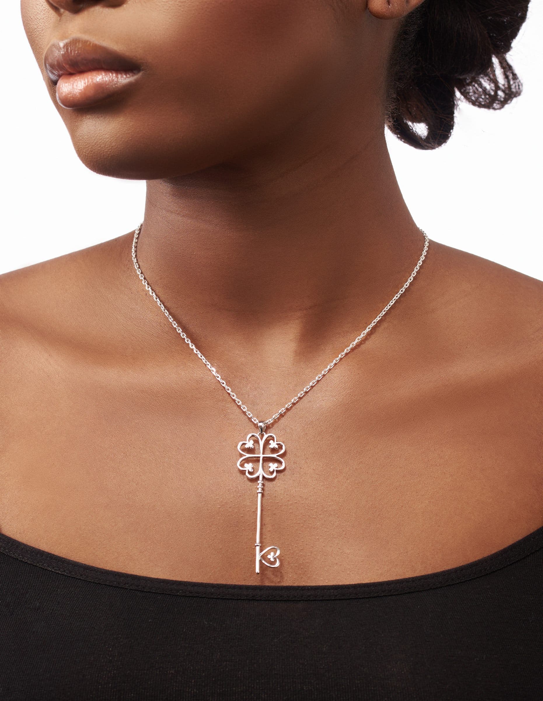 Key pendant on a fine chain worn at the collarbone