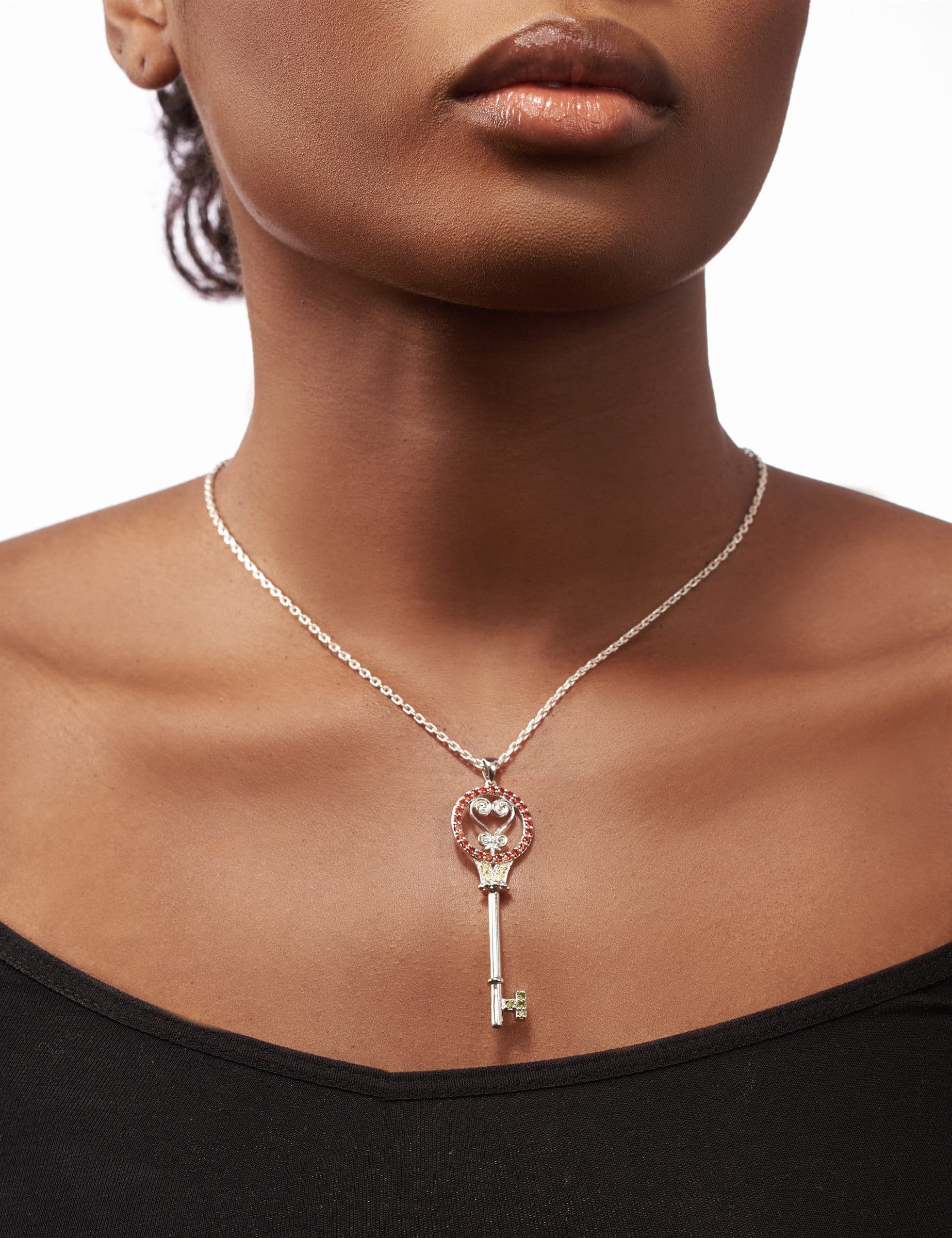 Second key pendant, worn against a black neckline
