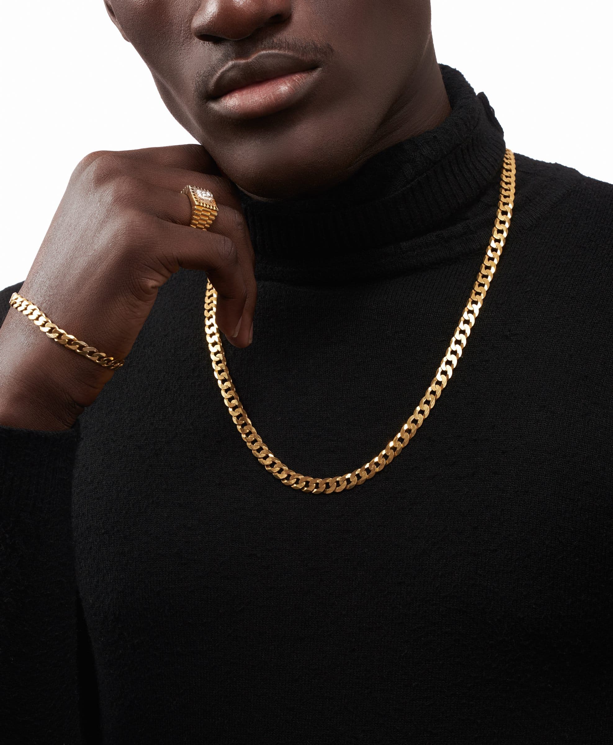 Gold chain and signet ring worn with a black turtleneck